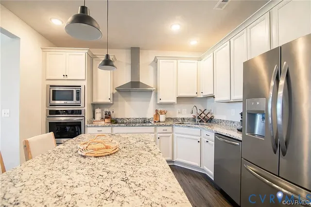 a kitchen with a refrigerator sink and white cabinets