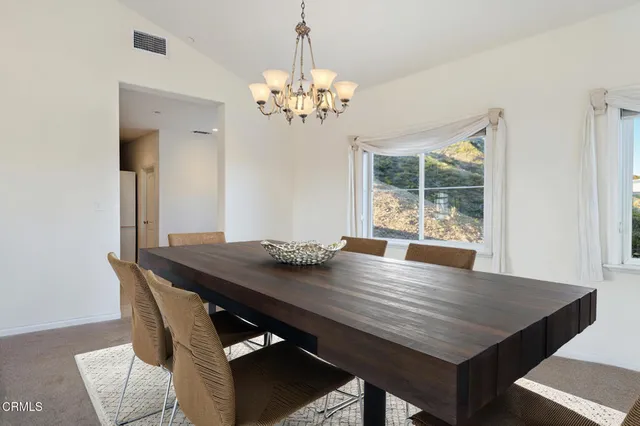 a view of a dining room with a table and chairs