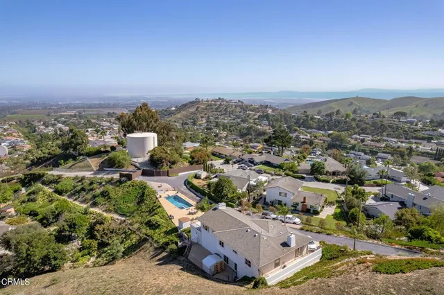 an aerial view of a house with a yard and lake view