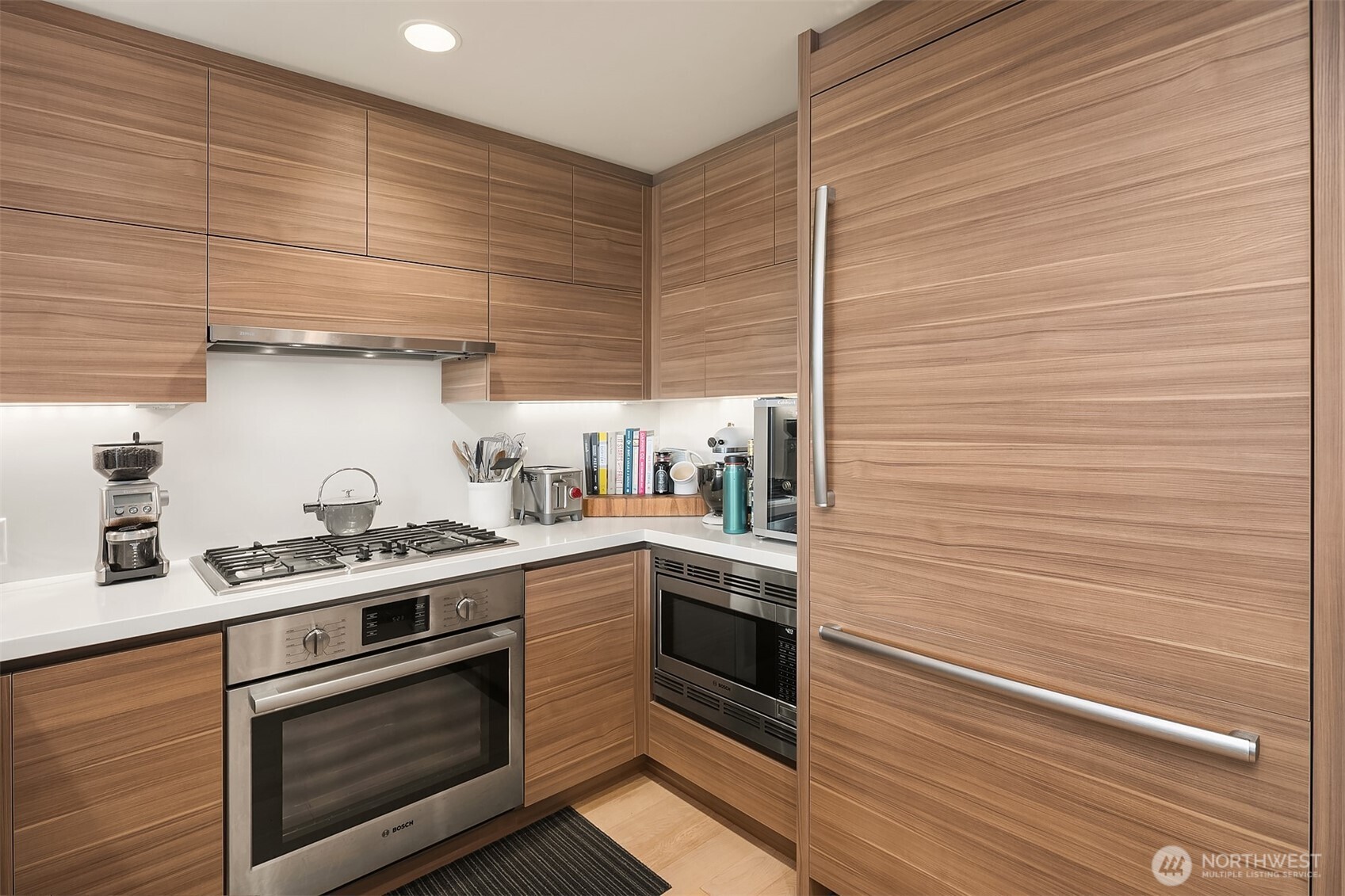 583 Battery Street, Unit 1405N Seattle, WA 98121 - Photo 10 of 37 a kitchen with stainless steel appliances wooden cabinets and a stove