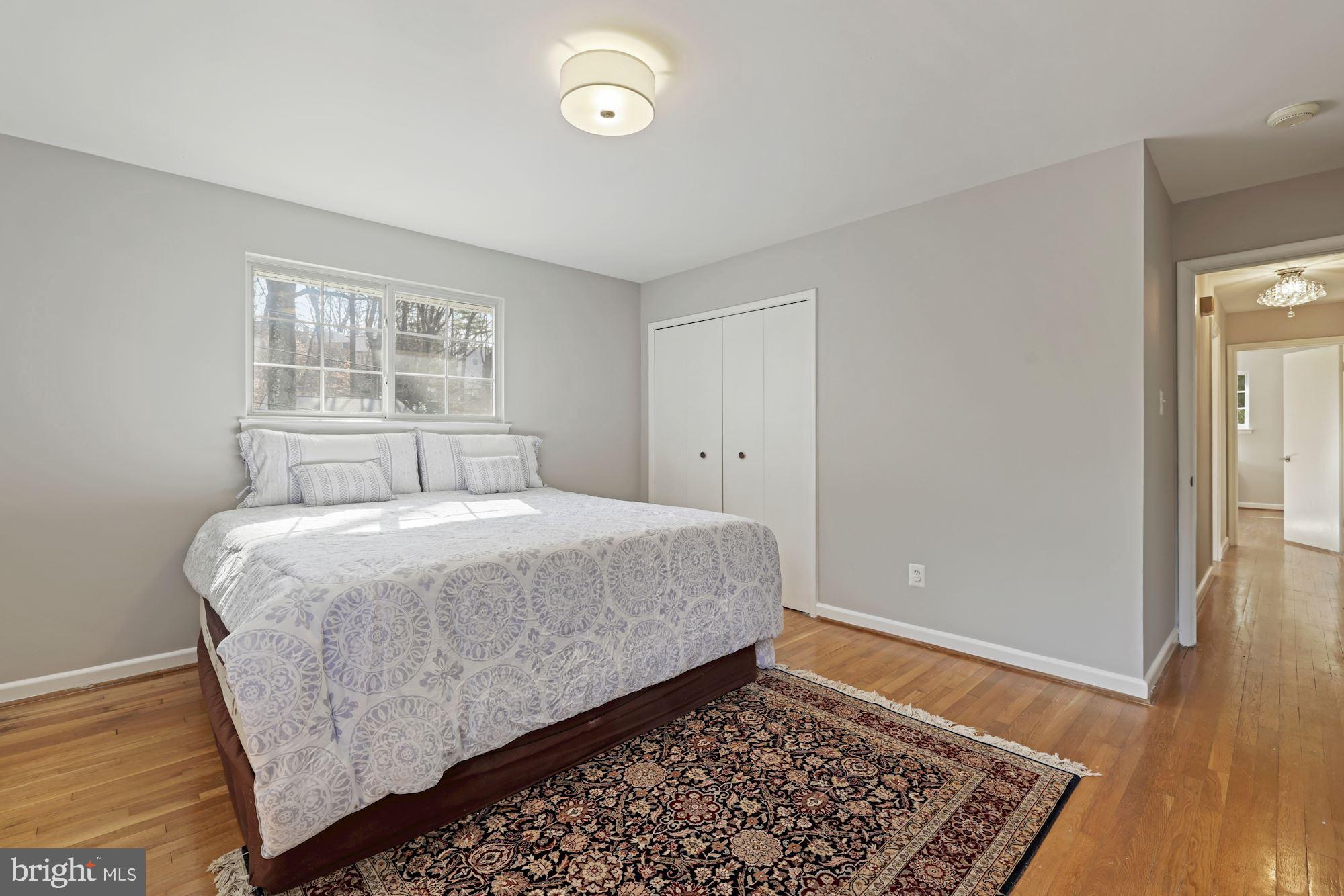7716 Beech Tree Road Bethesda, MD 20817 - Photo 38 of 49 a bedroom with a bed and wooden floor