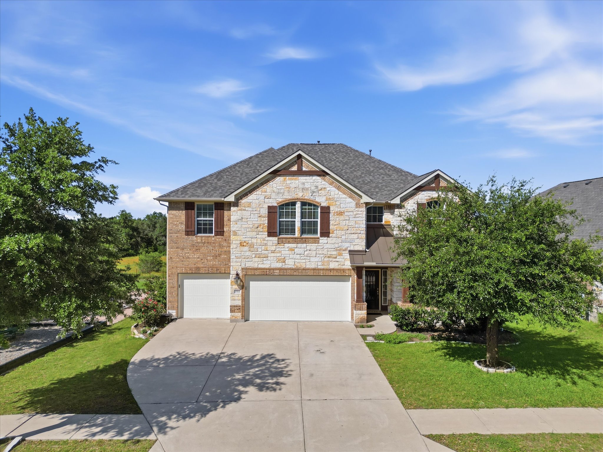 1511 Rimstone Drive Cedar Park, TX 78613 - Photo 4 of 39 A remarkable luxury home has well-maintained facade features a mix of brick and stone, offering a classic and inviting curb appeal.