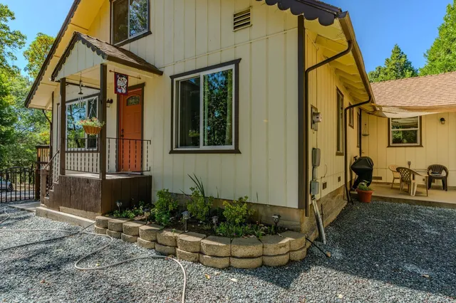 an aerial view of residential house with outdoor space and trees all around