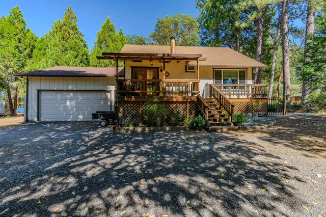 an aerial view of a house with a yard and a large tree