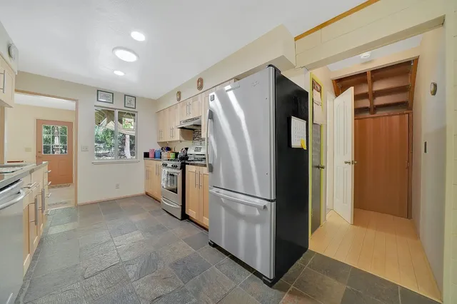 a kitchen with a refrigerator a stove a sink dishwasher and white cabinets with wooden floor