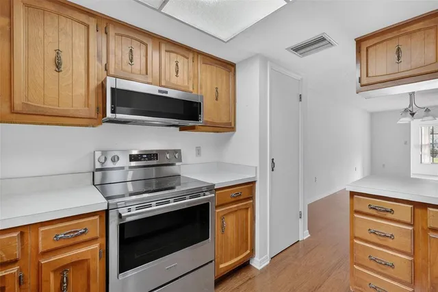 a kitchen with stainless steel appliances granite countertop white cabinets and a stove top oven