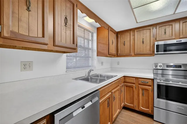 a kitchen with stainless steel appliances granite countertop a sink a stove and cabinets
