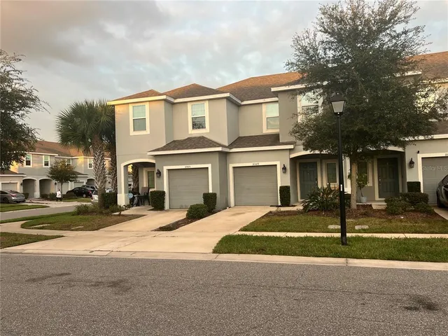 a view of a white house with a large windows and a table and chairs