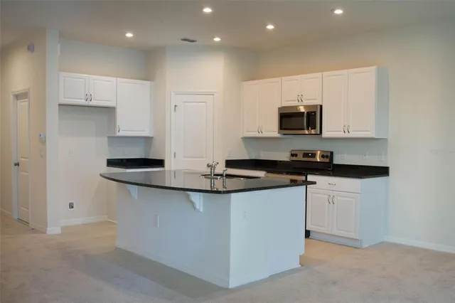 a kitchen with stainless steel appliances granite countertop a sink and a stove