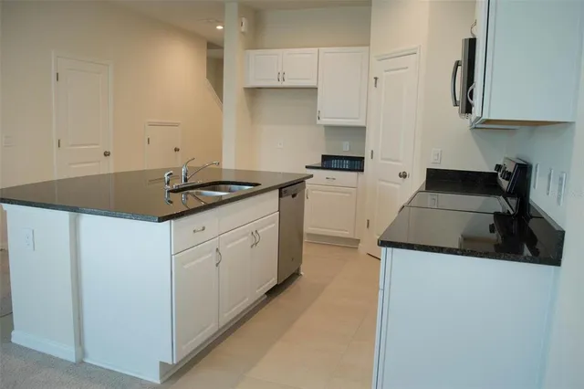 a kitchen with a sink and a stove top oven