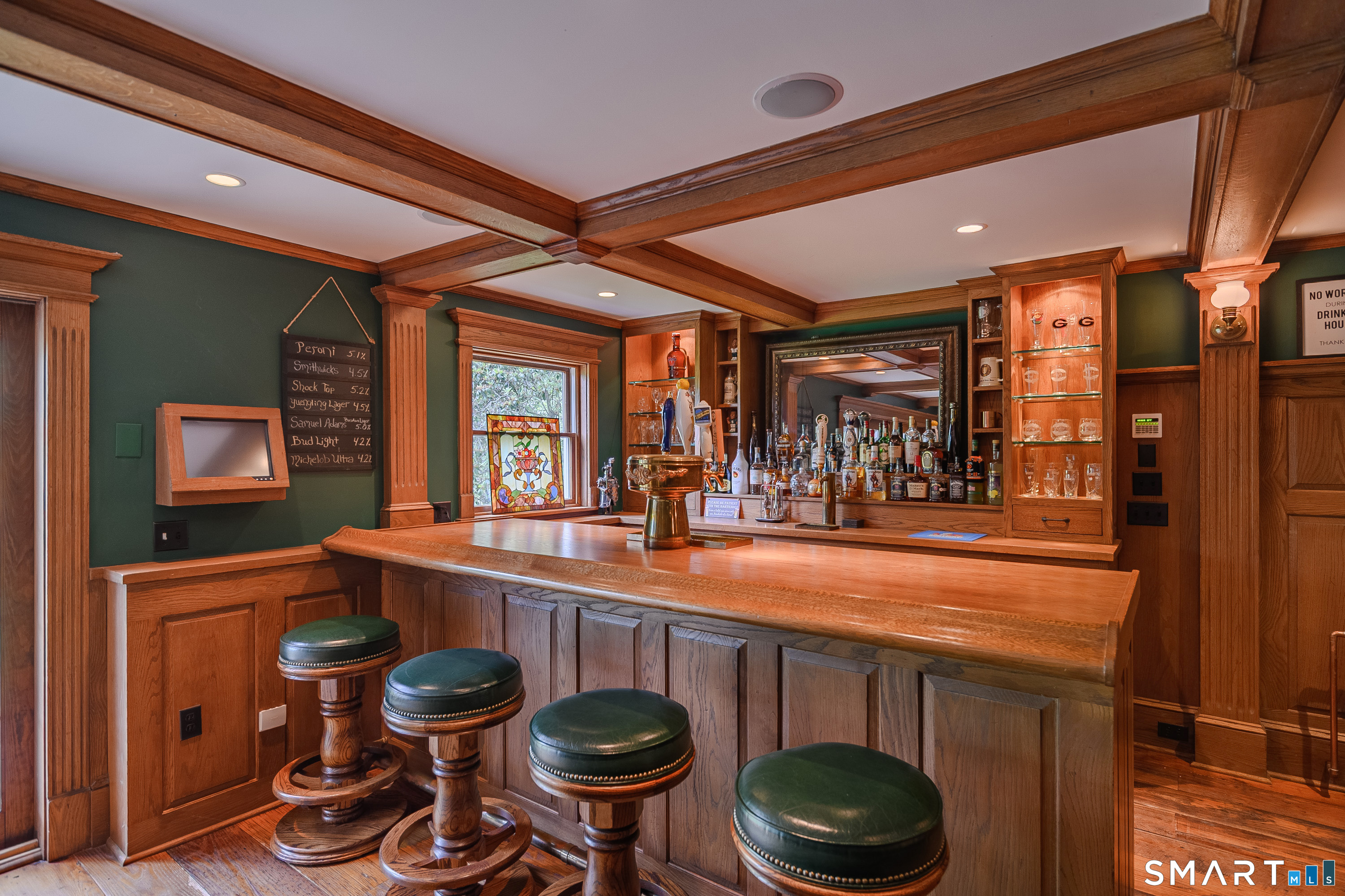 16 Farm Meadow Road Newtown, CT 06470 - Photo 30 of 40 Custom built-in bar with detailed craftsmanship, beverage taps, and warm inviting ambiance perfect for entertaining.