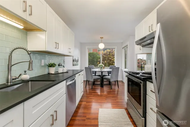 a kitchen with stainless steel appliances granite countertop sink stove top oven and cabinets