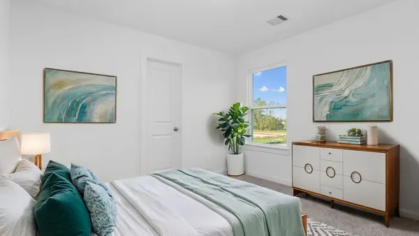 a bedroom with a bed and a potted plant