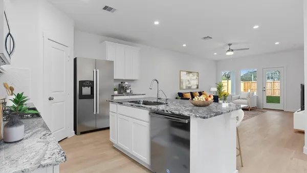 a kitchen that has a lot of cabinets a sink and a refrigerator