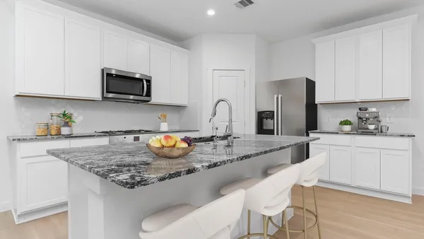 a kitchen with stainless steel appliances granite countertop a sink a stove a microwave a refrigerator and cabinets