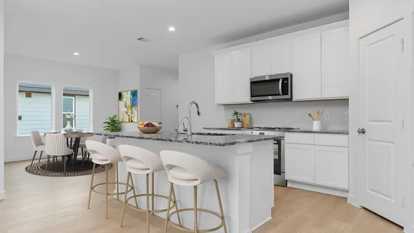 a kitchen with granite countertop white cabinets and stainless steel appliances