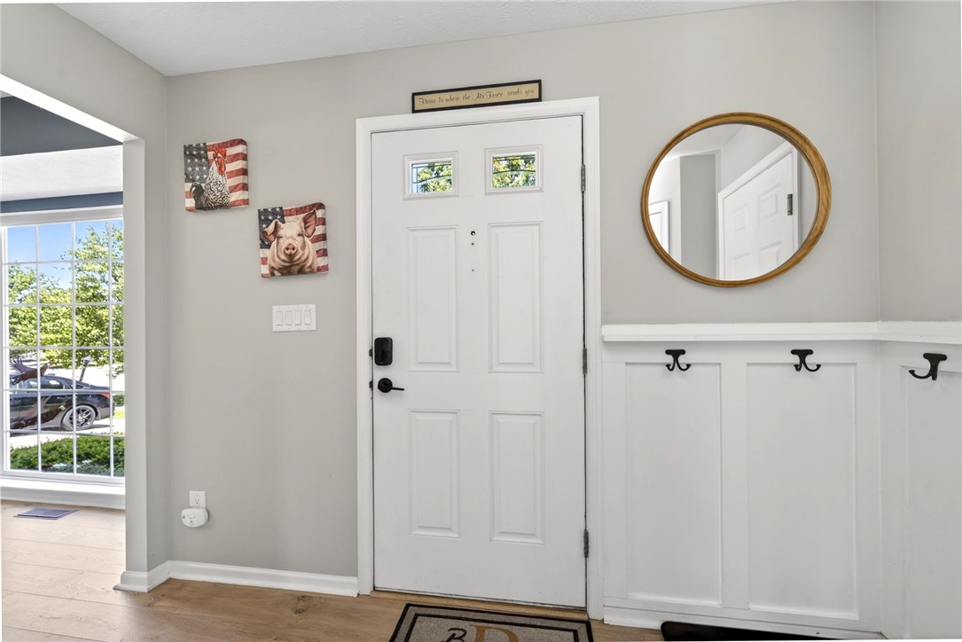 39 Holly Court Springboro, OH 45066 - Photo 5 of 42 The bright entry features a pristine door with decorative glass panels and durable wood flooring.