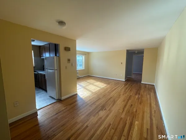 a view of empty room with wooden floor