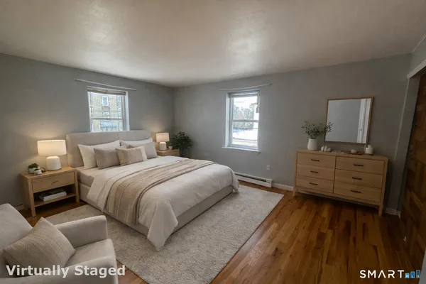 a bedroom with a bed and wooden floor