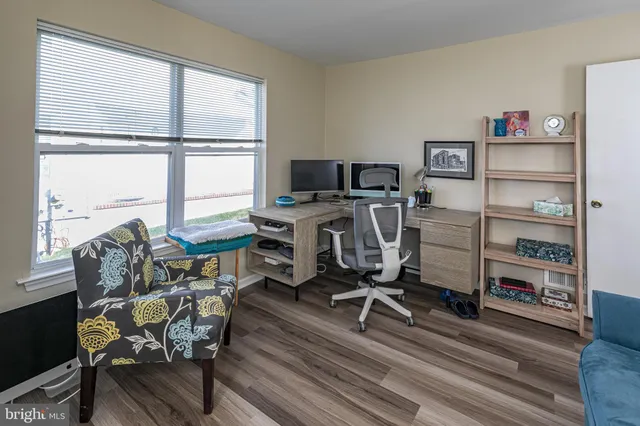 a view of a workspace with furniture and a window