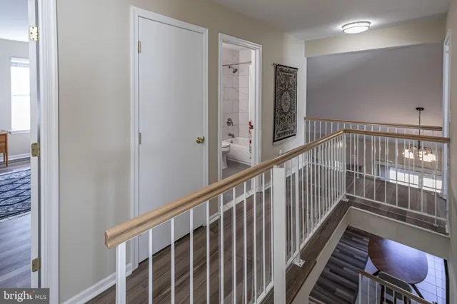 a view of a hallway with wooden floor and stairs