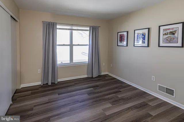 a view of a room with wooden floor and window