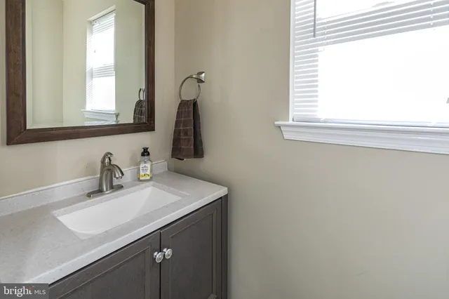 a bathroom with a sink vanity and a mirror