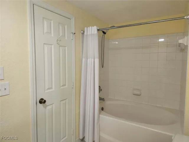 an empty room with a ceiling fan and a window