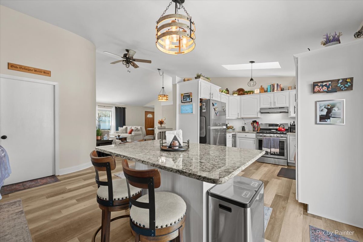 920 Mensching Road Roselle, IL 60172 - Photo 8 of 40 a kitchen with granite countertop kitchen island stainless steel appliances a table chairs and stove