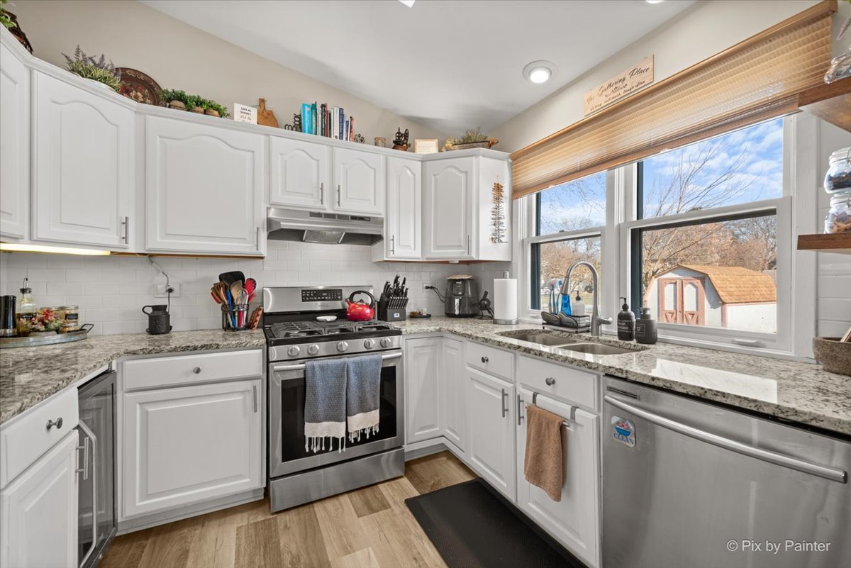 920 Mensching Road Roselle, IL 60172 - Photo 10 of 40 a kitchen with granite countertop white cabinets and white stainless steel appliances