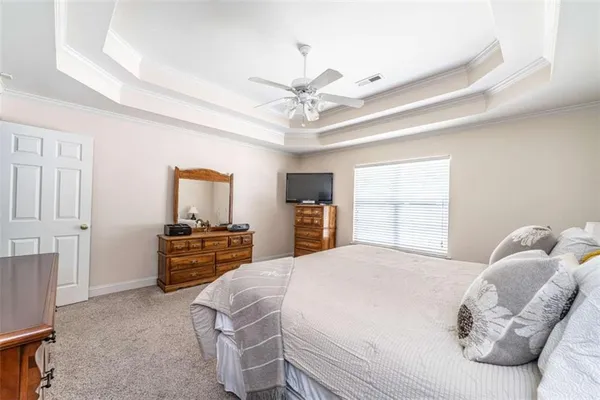 a bedroom with a bed dresser and window