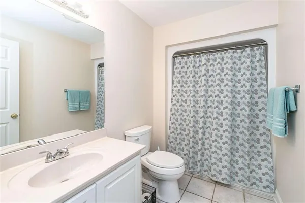 a bathroom with a sink a toilet and shower curtain