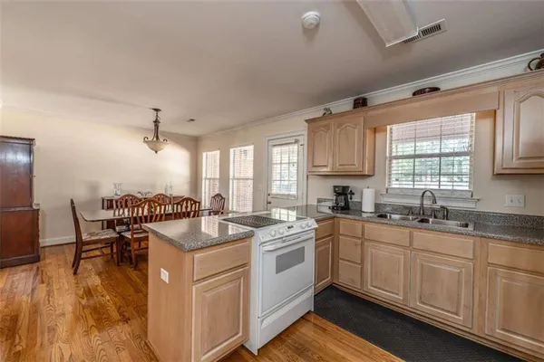 a kitchen that has a sink and chairs in it