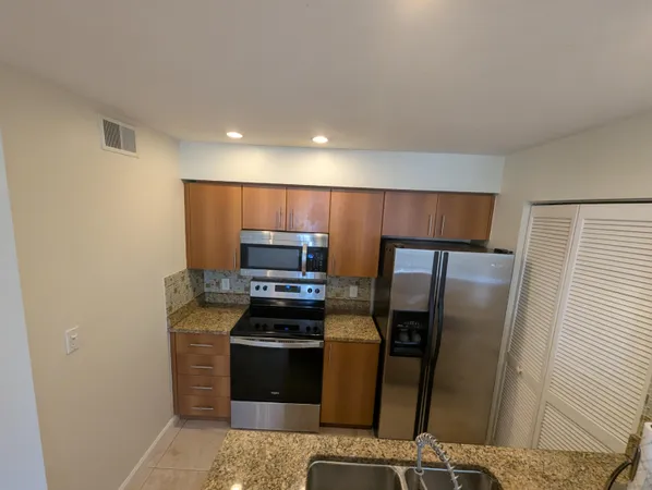 a kitchen with stainless steel appliances a refrigerator and a stove