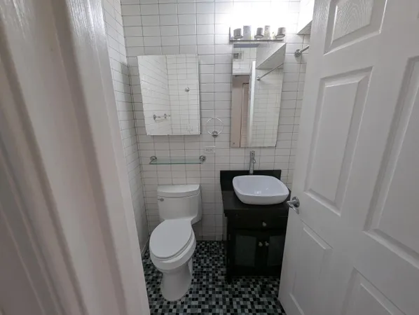 a bathroom with a granite countertop toilet and a sink