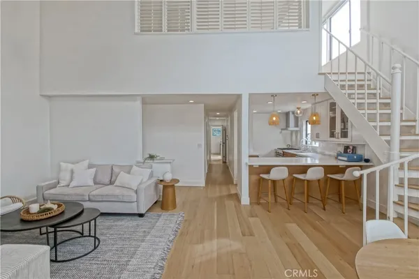 a living room with furniture a rug and kitchen view