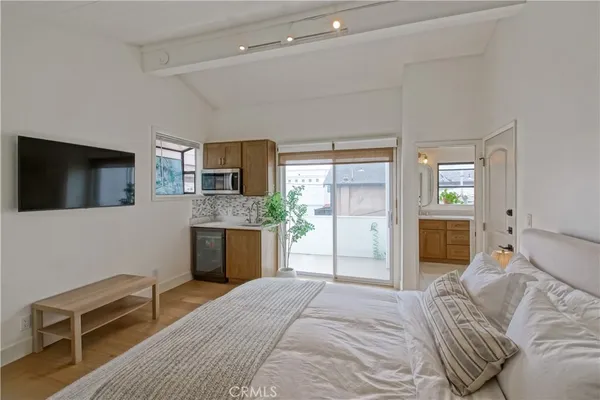a bedroom with double bed and a large mirror next to a large window