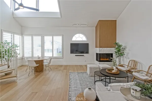 a living room with furniture a flat screen tv and a large window