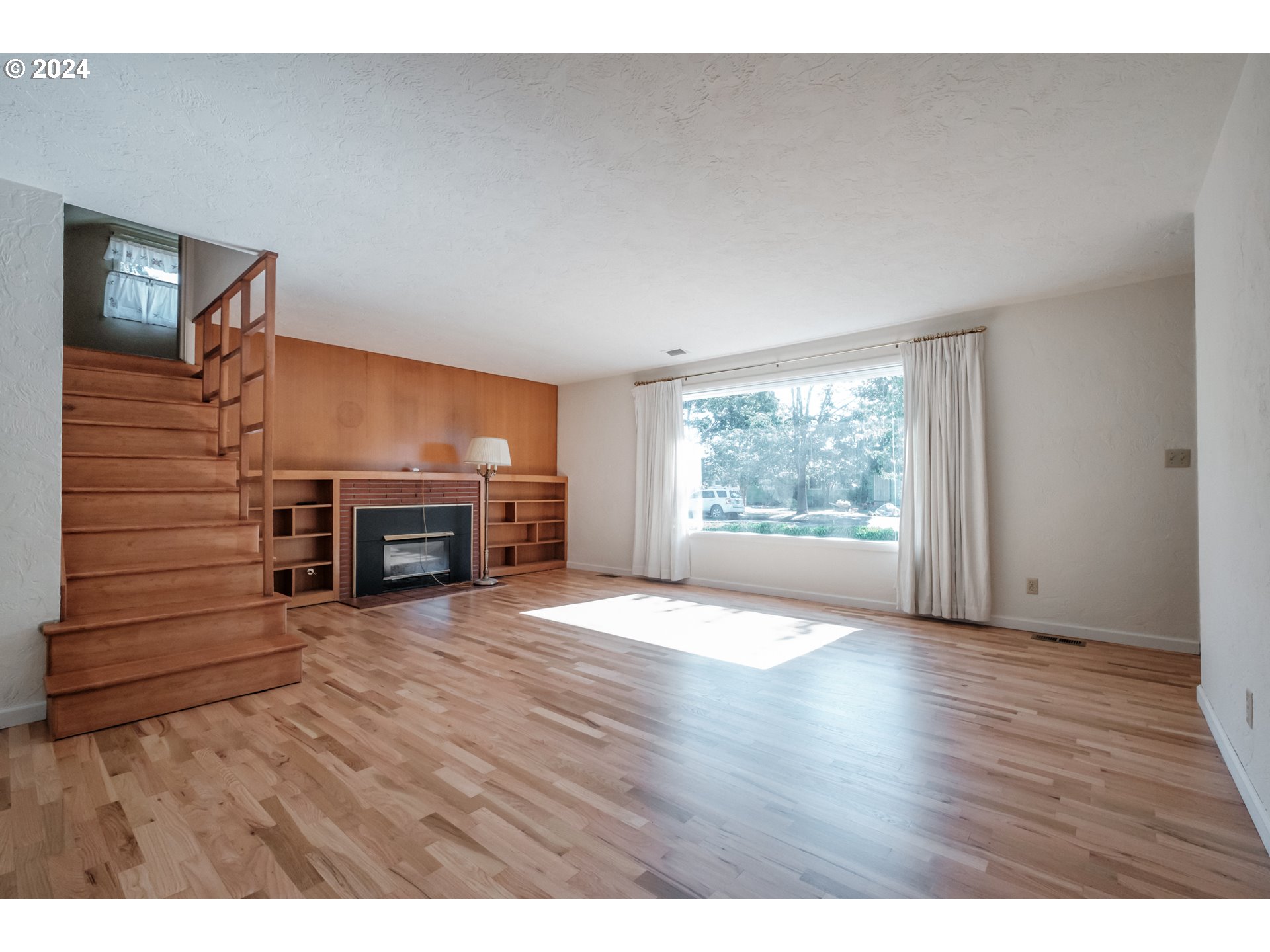 1620 Market Street Springfield, OR 97477 - Photo 8 of 31 a view of an empty room with wooden floor fireplace and a window