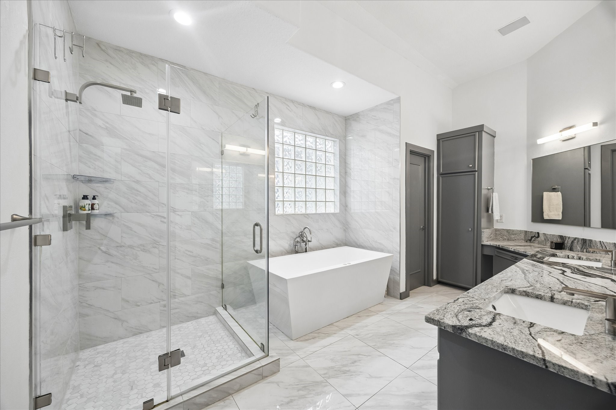 6406 Rodrigo Street, Unit B Houston, TX 77007 - Photo 20 of 27 Primary bathroom with separate glass enclosed shower, jetted tub, linen closet and vanity with dual sinks.