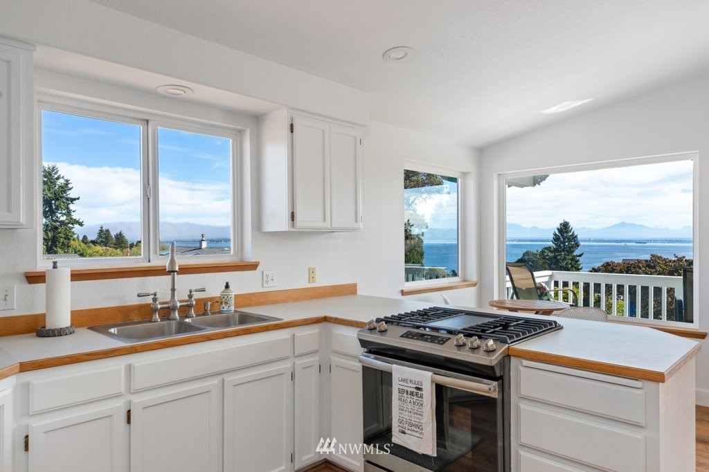 6623 Humphrey Road Clinton, WA 98236 - Photo 17 of 40 a kitchen with a stove a sink and a window