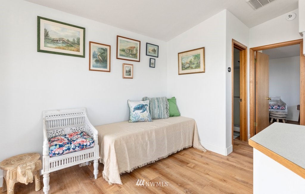 6623 Humphrey Road Clinton, WA 98236 - Photo 19 of 40 a bedroom with a bed and paintings on the wall