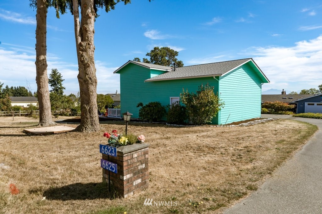 6623 Humphrey Road Clinton, WA 98236 - Photo 6 of 40 a front view of a house with a yard and potted plants