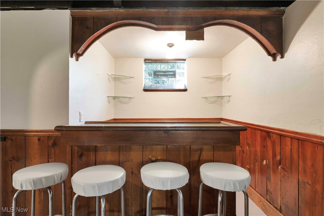 3385 Rosedale Road Cleveland, OH 44112 - Photo 30 of 40 Indoor dry bar featuring wainscoting and wooden walls