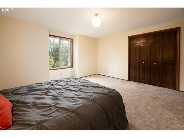 a spacious bedroom with a bed and a large window