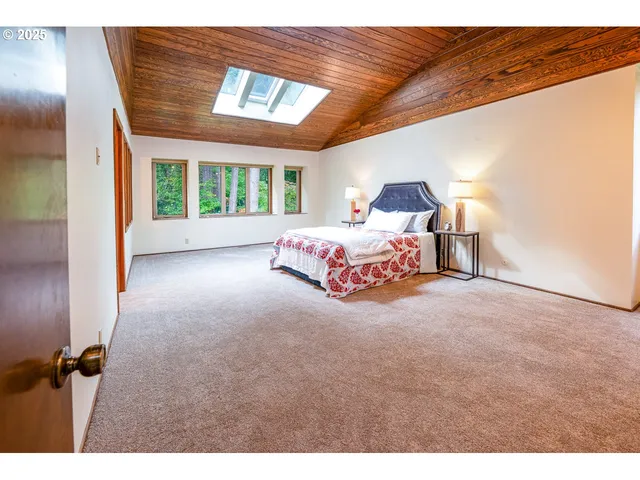a bedroom with a large bed and a chandelier