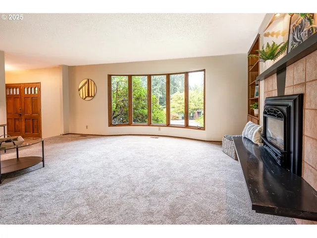 a view of an empty room with a fireplace and a window