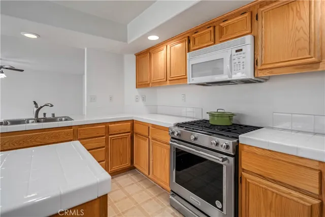 a kitchen with stainless steel appliances granite countertop a stove a sink and a microwave