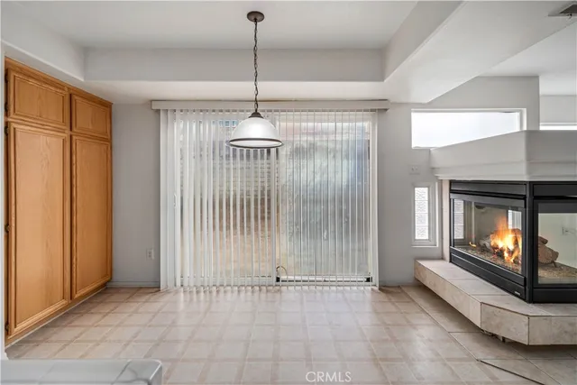 a view of an empty room with a fireplace and a window