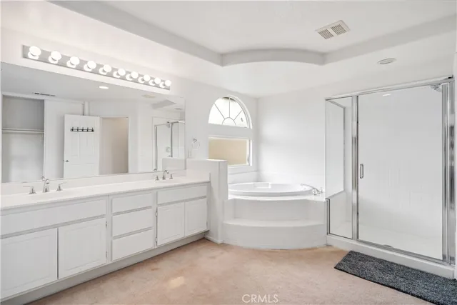 a bathroom with a double vanity sink mirror and bathtub